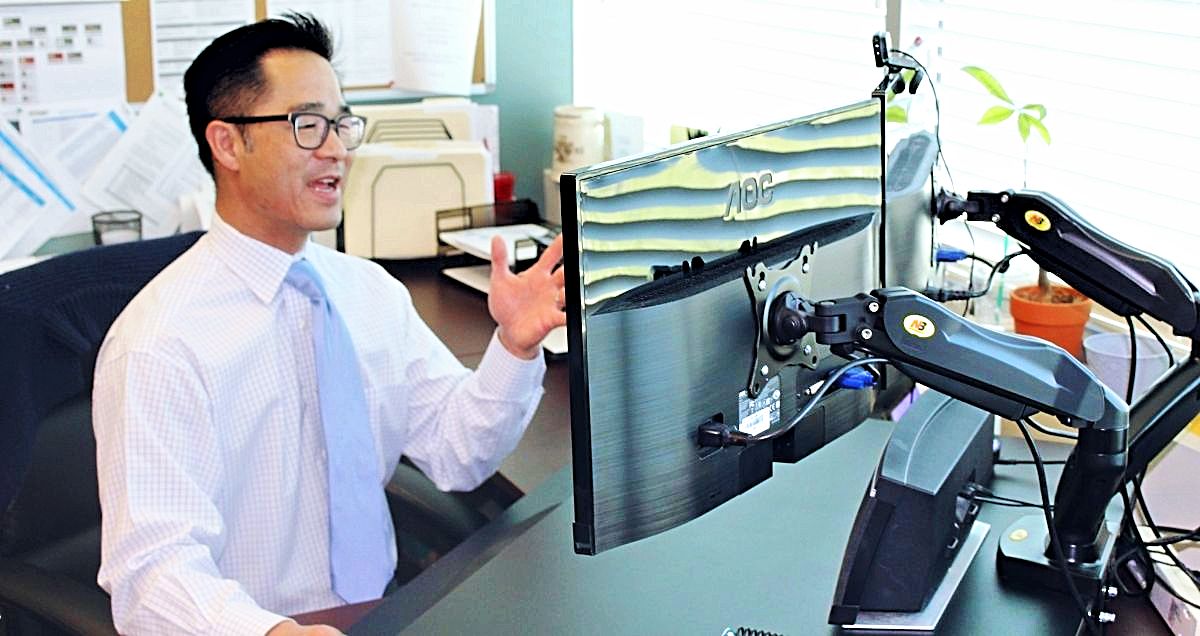 A talking doctor having a Telemedicine appointment on his computer at his desk.