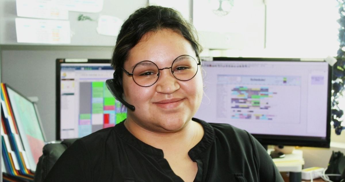 A Customer Care Team member at her desk with a headset on ready to take customer calls.